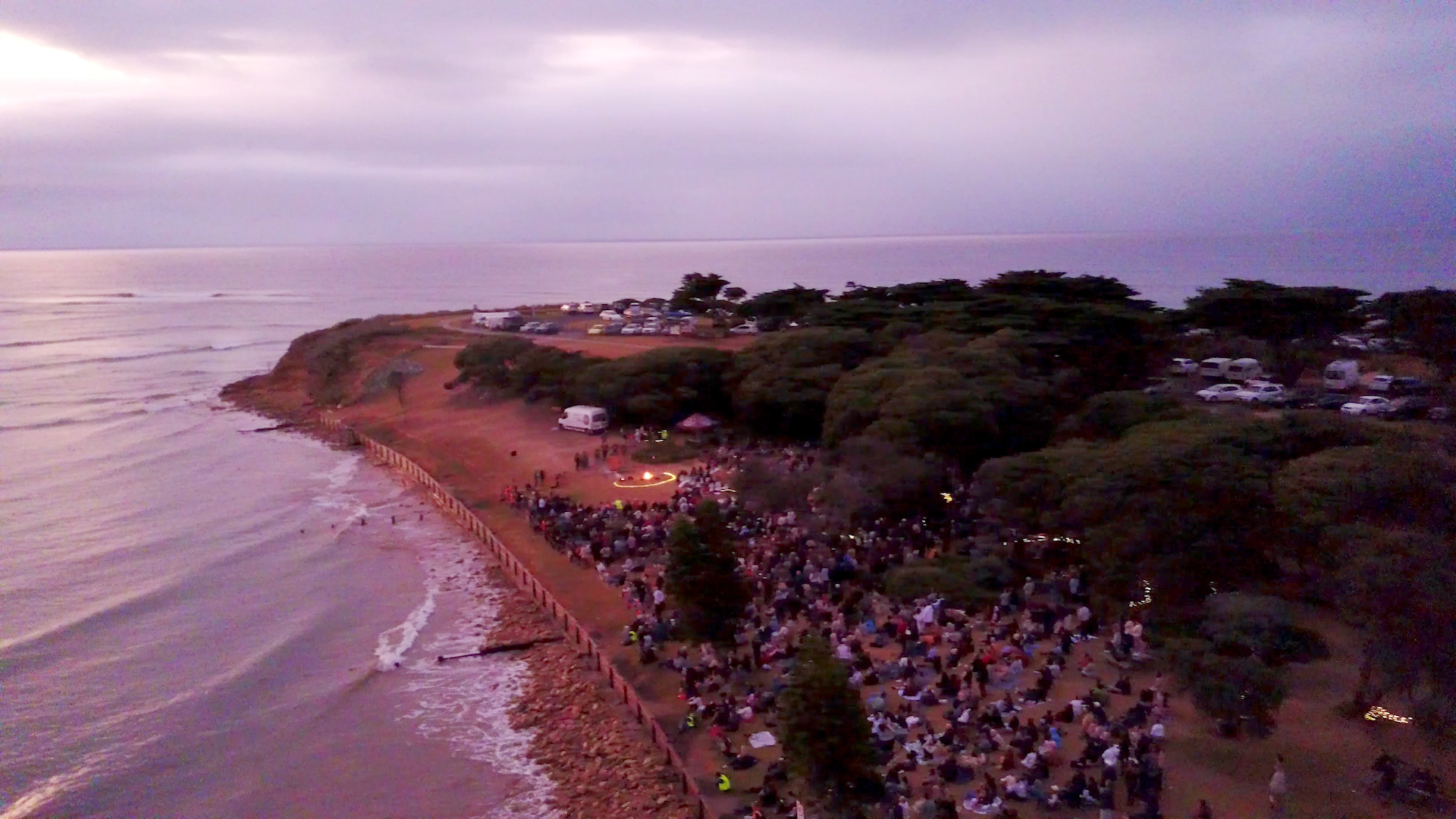 Photo from a drone with view of surf coast and people at the ceremony.