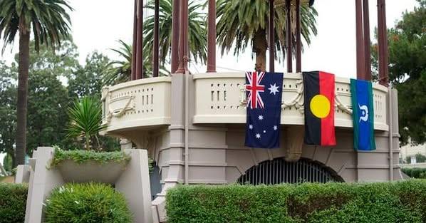 Stone Band Stand in the park showing 3 flags, Australian, Aboriginal and Torres Strait Islander.