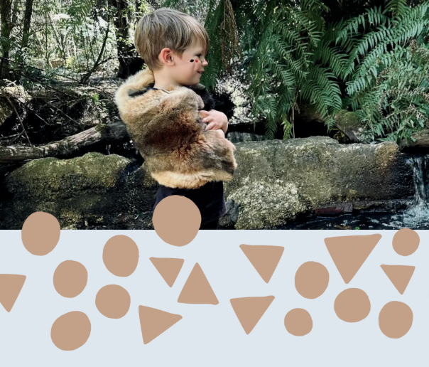 Young boy in nature with possom skin cloak around his shoulders